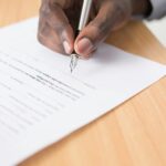 a man's hand filing a loan application document